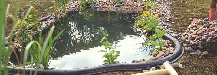 Gartenteich mit Schaufel und Rechen während der Bauphase.